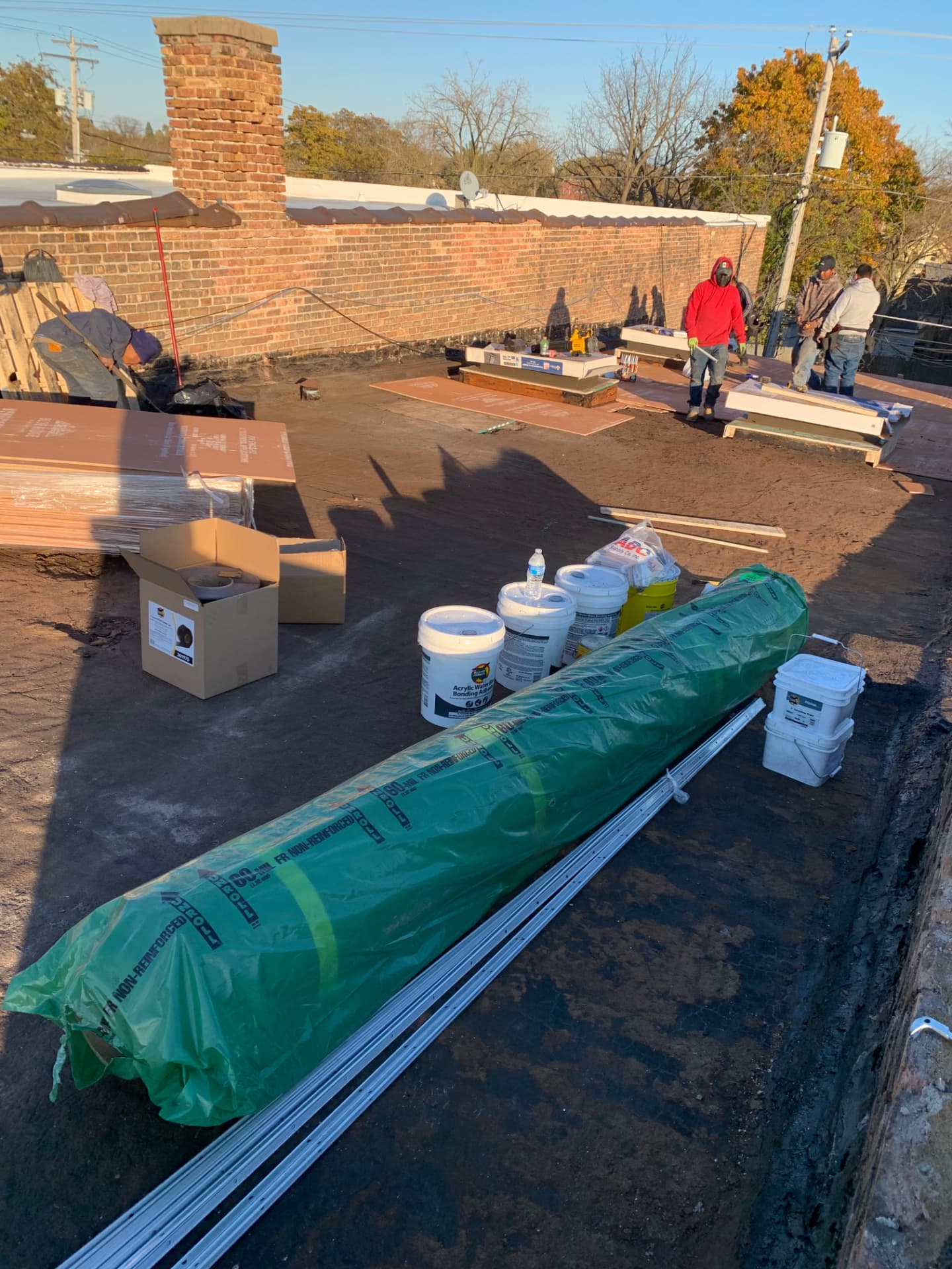 Crew preparing insulation board on a commercial flat roof